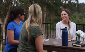 Parents enjoying a drink at picnic table, on parents retreat